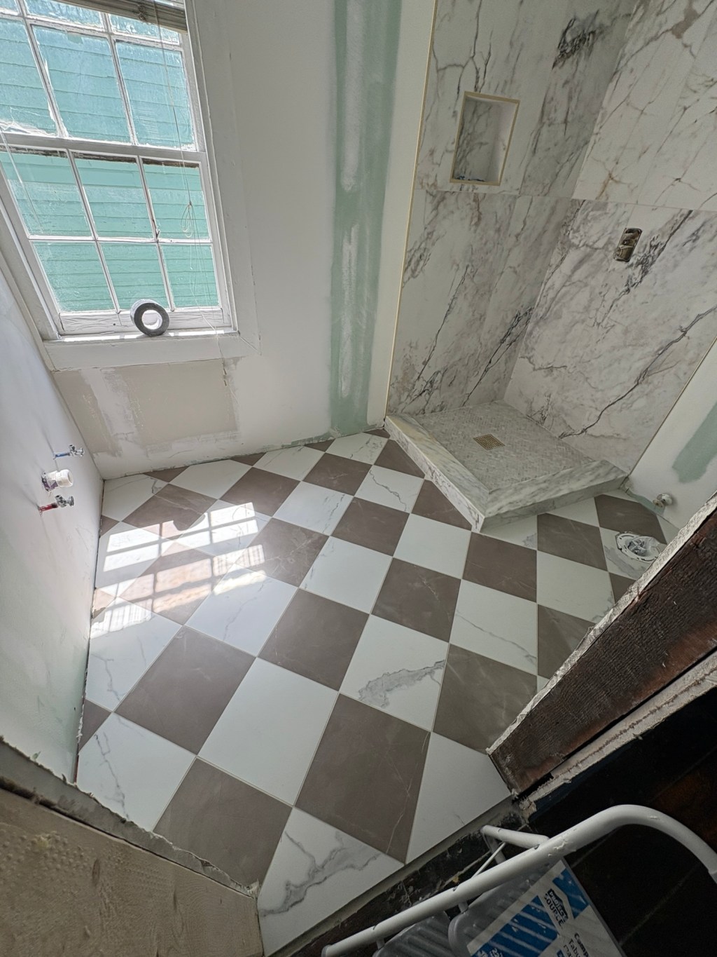 White and taupe diamond pattern tile in small bathroom.